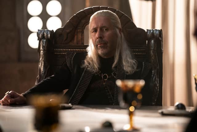 Paddy Considine as King Viserys I Targaryen, sat at the head of the small council, a goblet on the table before him (Credit: HBO)