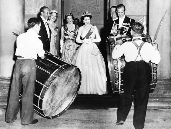 John Warden Brooke, 2nd Viscount Brookeborough (L), Queen Elizabeth II (C) and her husband Prince Philip, Duke of Edinburgh listen to drummers, on July 3, 1953 during their official visit to Northern Ireland.