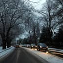 Cars drive on snowy roads.