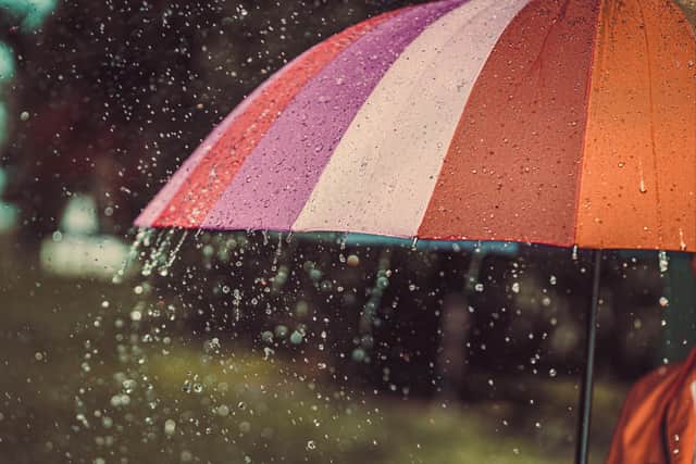 A stock image of an umbrella in the rain.