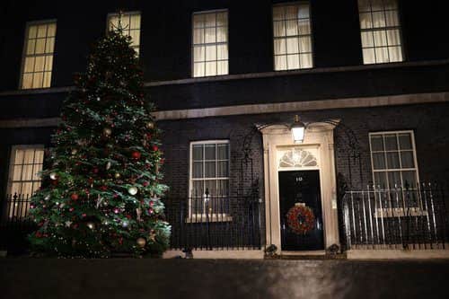A Christmas tree stands illuminated outside number 10 Downing Street (Getty Images)