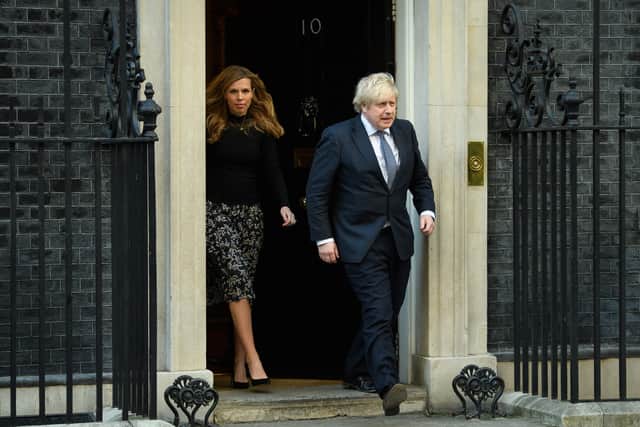 Prime Minister Boris Johnson and his partner Carrie Symonds stand outside the door of number 10 Downing Street (Photo by Leon Neal/Getty Images)