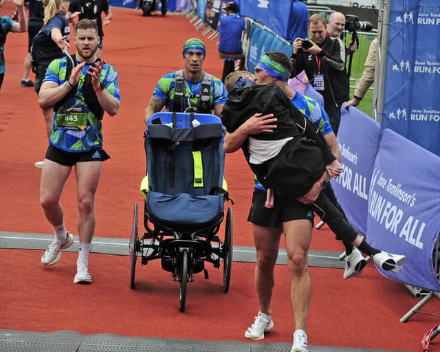 Last year, thousands of people watched the emotional moment Leeds Rhinos legend Kevin Sinfield carried his former teammate Rob Burrow over the finish line. Photo: Steve Riding.