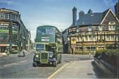 This view looks east along York Street towards the junction with Duke Street, showing a number 54 bus bound for Rodley. To the right of the image is the Lloyds Arms public house, since demolished. On the left is Munro House; the ground floor here is occupied by Walter Wragg Ltd., motor car agents and dealers.