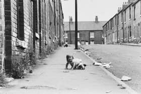 Hard times for 15-month-old Tammy Clarke among the broken glass and debris of Queen Street in July 1979.