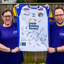 Sally Gutteridge, 49, with husband Jon Gutteridge, 42, holding up a signed Leeds Rhinos shirt which will be raffled for charity. Photo: James Hardisty 