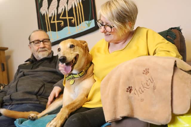 Jake on adoption day with new owners Veronica and Keith.JPG