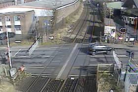 A car ignoring the signals and crossing the other side of the road to quickly dodge the closing barriers (Langley Green level crossing, West Midlands).  