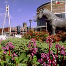 Tetley's Brewery Wharf Museum, right, which opened on March 19, 1994, beside the River Aire and closed in 2000. There is a sculpture of a Tetley's shire horse, and beyond Centenary Bridge accessing The Calls across the river. The tower of Leeds Parish Church of St. Peter, can be seen in the background