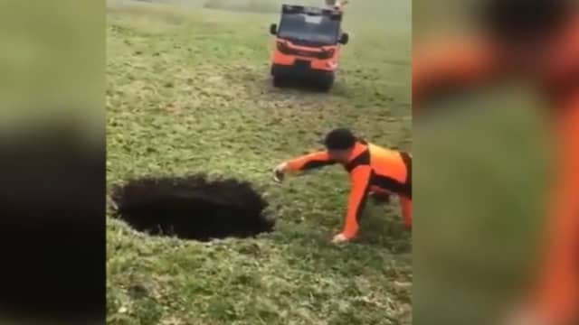 Hiker points to a giant sinkhole estimated to be around 20m deep