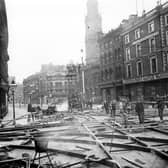 The junction of Briggate and Boar Lane during the relaying of tram tracks in 1899. The tracks were made at Hunslet Steel Works and laid out in a network. The spaces were filled with end grain wood blocks in this particular area instead of the usual stone setts in an effort to reduce noise. In the background is the spire of the Holy Trinity Church.