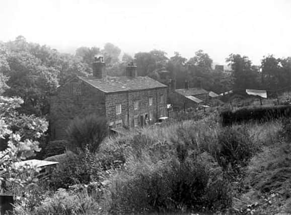 Long shot of stone built cottages on Scotland Mill Lane in September 1959. On the left are numbers 6 to 3 with numbers 2 and 1 seen towards the right, lower with protruding outbuildings. The cottages were originally built to house Scotland Millworkers. The mill itself burnt down in 1906.