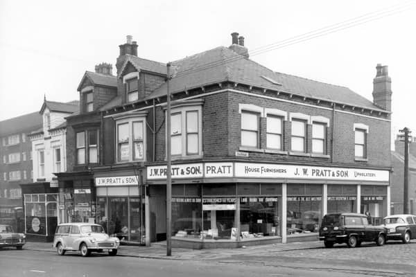 Beeston Road in October 1963. The shops on Beeston Hill including at number 101 (just visible) Marsh Jones & Cribb Ltd, painting contractors. At number 103 is a grocers advertising cigarettes and Typhoo Tea. On the right at numbers 105 & 107 is V.W. Pratt & Son, house furnishers and upholstery. Advertised in the window are 'The latest designs always on show'. On the right cars including the Una Street while more cars are parked on Beeston Road.