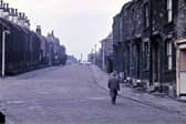 Looking up Ackroyd Street from the doorway of Morley Friends' Adult School in November 1962. Cobblestones still cover the road surface and there appears to have been an accident up the street. An Army lorry that had been parked outside the Drill Hall alongside the pavement on the right has seen its brakes fail, run downhill, bumped into a car and then careered across the road into the wall of a house at the other side.