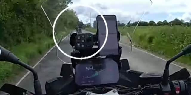 Speeding biker pulls a wheelie.