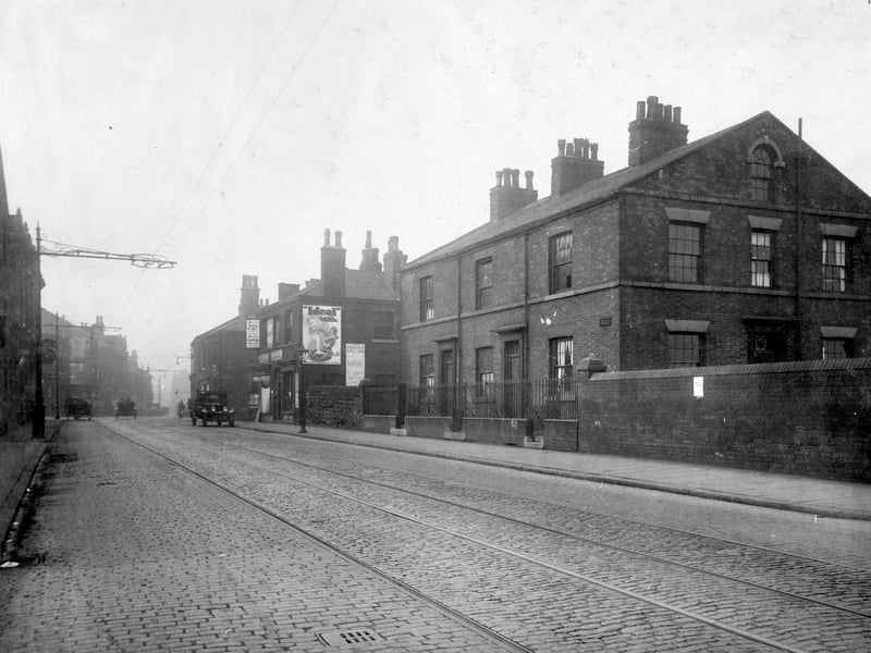 Low Road in September 1929 looking towards junction with Waterloo Road and Hunslet Road. Lorry on right side of road is at the junction with Highgate Street. Number 7 Low Road is newsagents with blind over window, John Normington. Next door, number 9 is boot repairer John Benson Hardaker. This shop has 'ideal' milk poster on wall. There are other vehicles on road, tramlines can be seen.