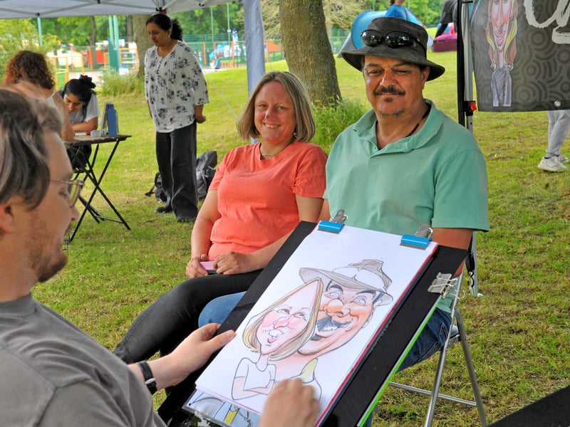 Sarah Thorpe and Geoff Smith wait as their caricature takes shape.