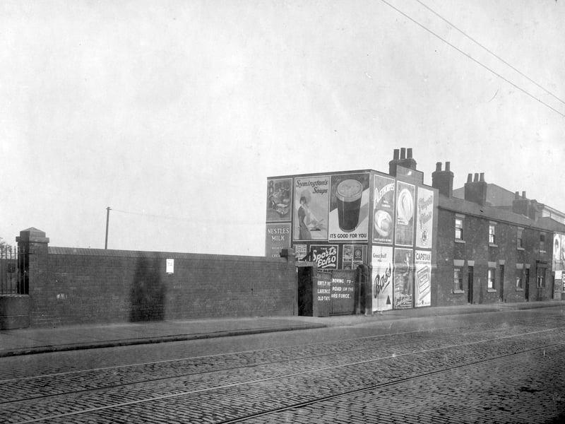 Low Road in October 1929. The yard in the centre is the former premises of Thomas Henry Fielding, cooper. Advertising hoardings with posters for Symingtons soups, Guiness, Bass beer, Palethorpes sausages. Almost hidden on the right, with roof visible, is the Hunslet Baptist Tabernacle.
