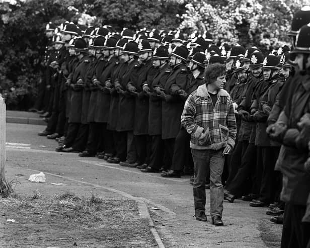 A picket inspects a line of police officers outside the Orgreave coking plant in June 1984.