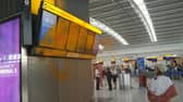 Just Stop Oil cover Heathrow Airport Terminal 5's departure boards in orange paint.