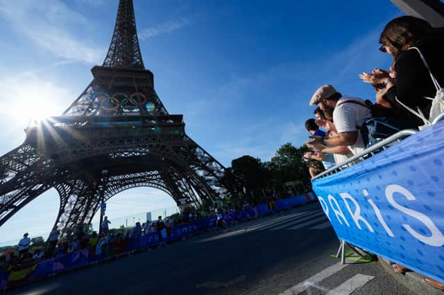 Spectators react as competitors run passed the Eiffel Tower during the Olympic Games Paris 2024. Photo: Rebecca Blackwell - Pool/Getty Images
