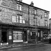 The west side of Hunslet Lane, at the junction with South Row in October 1947. Premises shown are as follows; number 58, D.E. Angus, dining rooms; number 60, D. Johnson, shopkeeper; number 62, N. Johnson, tobacconist and number 64, H. Sidebottom, greengrocer, where a woman looks out of the doorway. To the right a coal lorry is partially visible. It belongs to the business of Lockwood, Hargreaves & Co., coal merchants, of 51 Hunslet Lane. 