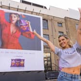 Ashley puts sweat shame to sweat fame by standing in front of her sweating billboard as the new face of Extra Flamin' Hot snacks