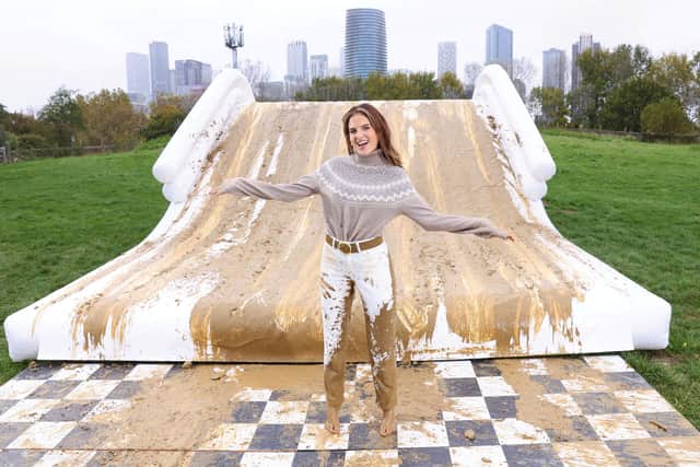 Binky Felstead encourages families to embrace the mud this half term as she's spotted going down a 2.5m high mudslide, created by Bosch at Mudchute Farm.