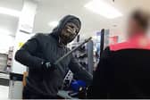 Moment armed robber in Halloween mask raids shop till.