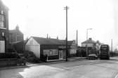 Tong Road in October 1968. In focus is Joseph Tate funeral directors, in business for five generations. Behind can be seen the Barchester Ales Brewery while on the right a number of people queue to get on the number 11 bus to Greenthorpes.
