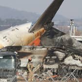 Firefighters check near the wreckage of a passenger plane at Muan International Airport 
