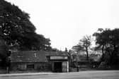 Old Smithy on N.E side of York Road, handcarts in yard to right of building, a man is standing outside. Just behind the Smithy is a half-timbered building with large trees on either side. Pictured in October 1949.