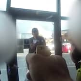 Marius Ciolac is seen standing outside the broken entrance doors of Ascot Drive police station in Derbyshire.