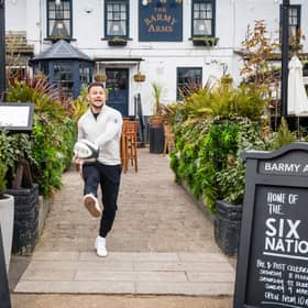 Former England rugby international Danny Care kicking a ball "into space" from outside the Greene King sport pub The Barmy Arms in Twickenham