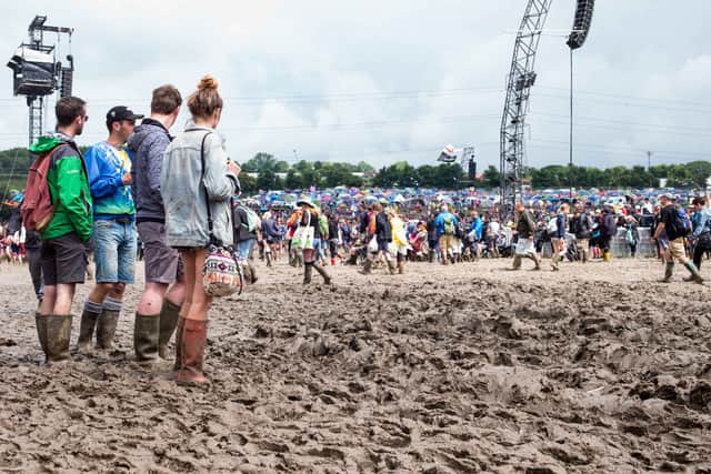 GLASTONBURY, ENGLAND - JUNE 25: Festival goers cope with muddy conditions on day 2 of the Glastonbury Festival at Worthy Farm, Pilton on June 25, 2016 in Glastonbury, England.