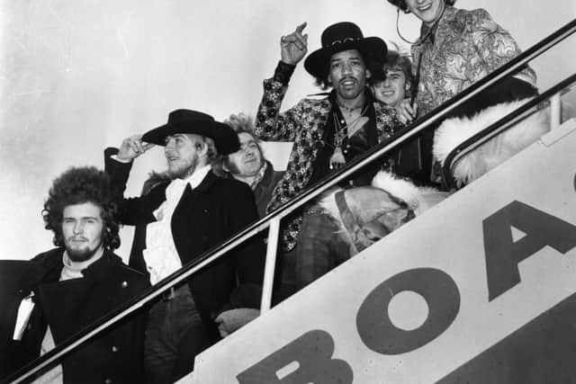 Jimi Hendrix and Mitch Mitchell of The Jimi Hendrix Experience wave goodbye as they board an aeroplane at London Airport, with assorted members of the Byrds, the Soft Machine and the Alan Price Set.