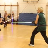 Two people, training with lightsabers