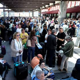 People wait outside the Atocha train station in Madrid after its closure as a massive power outage hits Spain.