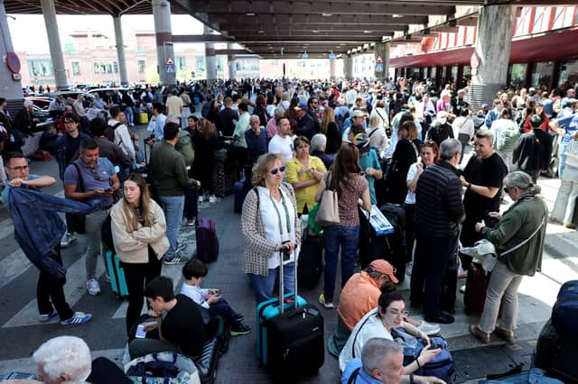 People wait outside the Atocha train station in Madrid after its closure as a massive power outage hits Spain.