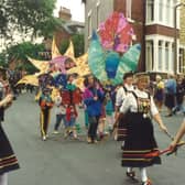 Kirkstall Festival in July 1991. The parade makes its way along Hesketh Road. Children are carrying home made models and Briggate Morris dancers can be seen with smocks, clogs and decorated bobbins.
