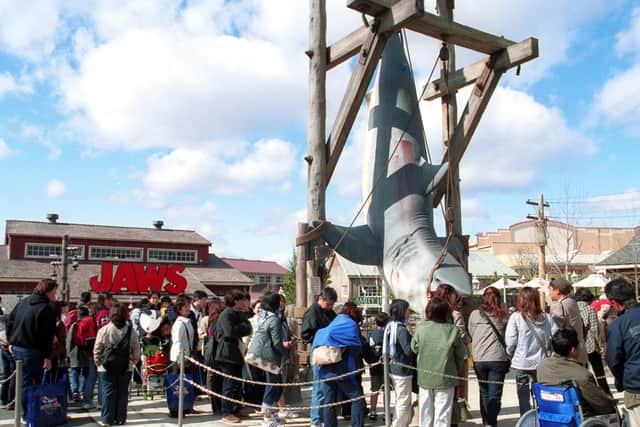 Visitors crowd around a hanging shark display near the ride, themed after the Steven Spielberg motion picture "Jaws," at Universal Studios during a pre-opening preview of the park March 29, 2001 in Osaka, Japan.