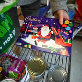 A Christmas chocolate selection box is unpacked in Weymouth Foodbank distribution hub in December 2023 (Photo: Finnbarr Webster/Getty Images)