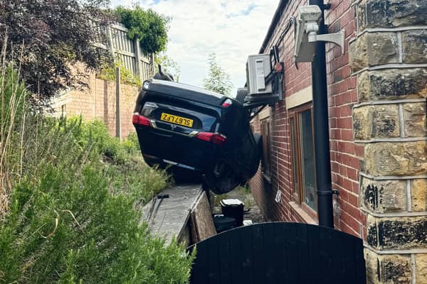 Shocking video shows the scene after a runaway car fell off a hill, flipped upside down, and crashed in to the window of a gym
