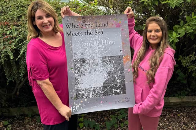 Sammi Shapero and Becky Joyce with the Damien Hirst poster which has been signed by the artist himself