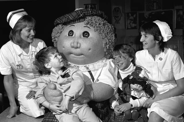 A giant Cabbage Patch Kid and 10-year-old Krisha Jacobs (with a Cabbage Patch doll) visit the Sick Children's Hospital in Edinburgh in October 1985