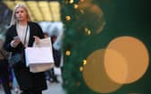 A shopper walks with her purchases along the main shopping street Oxford Street in London. Starting to save in September gives you three months to build a festive fund (Photo by DANIEL LEAL/AFP via Getty Images)