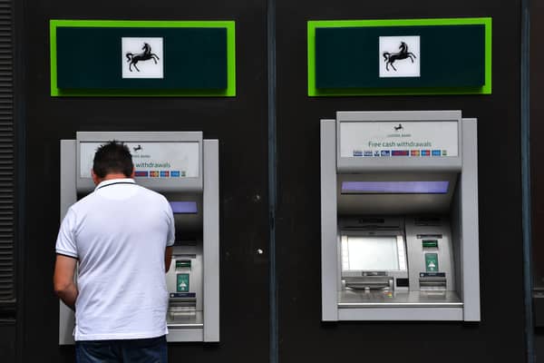 A man takes money from a cash machine at a branch of Lloyds Bank. The banking group will close 49 branches across the UK between January and October 2026 (Photo: Carl Court/Getty Images)