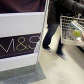 A shopper walks past a Marks and Spencer sign at a store at Covent Garden, London. M&S staff must work Boxing Day for the first time in five years (Photo: CARL DE SOUZA/AFP via Getty Images)