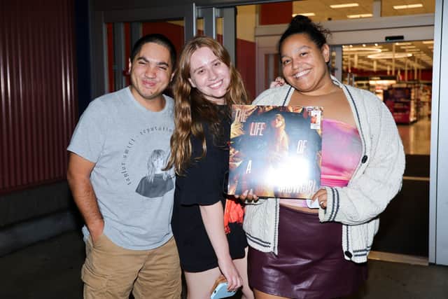 Fans pose with Taylor Swift's new album The Life of a Showgirl during the midnight release at Target on October 03, 2025 in Burbank, California.