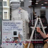 A woman walks past a Cancer Research UK store in London. The charity shop chain will  close 88 high street shops by May 2026, with 100 more expected by April 2027 (Photo: BEN STANSALL/AFP via Getty Images)